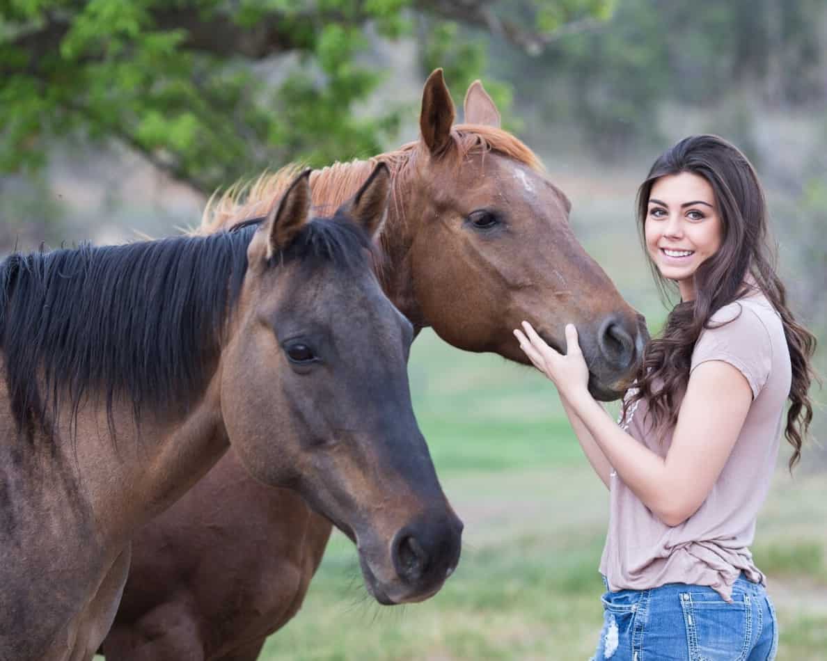 A Women Petting A Horse Outside